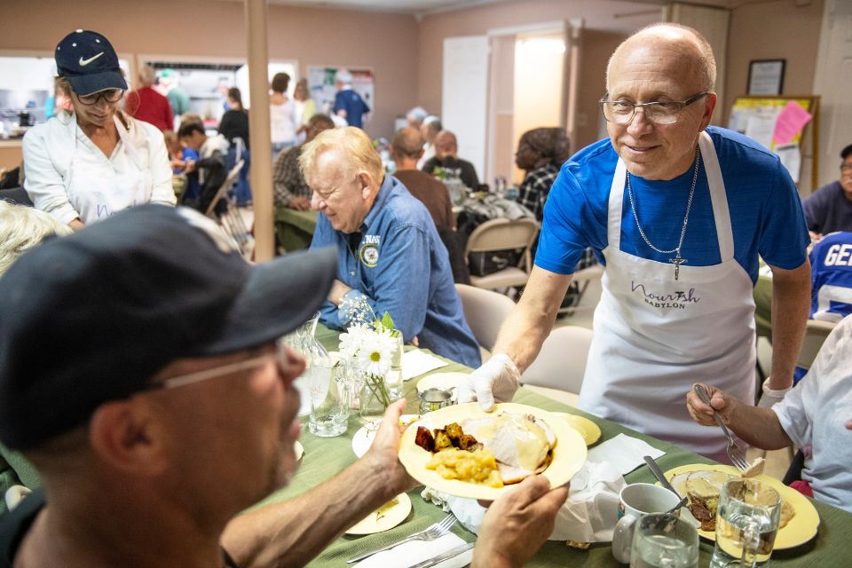 A Nourish Babylon volunteer serves a healthy, homemade meal to a community member at Christ Episcopal Church in Babylon during their weekly Monday night community meal.